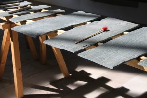 Ausschnitt eines großen Xylophons aus Schieferplatten mit Schlägel im Sonnenlicht