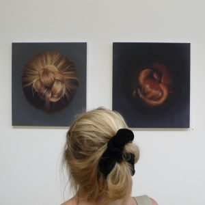 Frauenkopf (von hinten) vor zwei Haarbildern.
