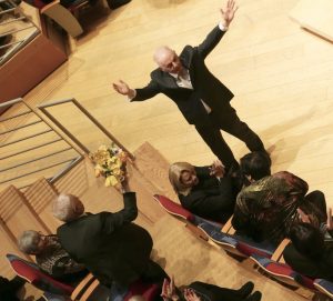 Im Konzert zu Frank Gehrys 90. Geburtstag überreicht ihm der Dirigent Barenboim seinen Blumenstrauß.